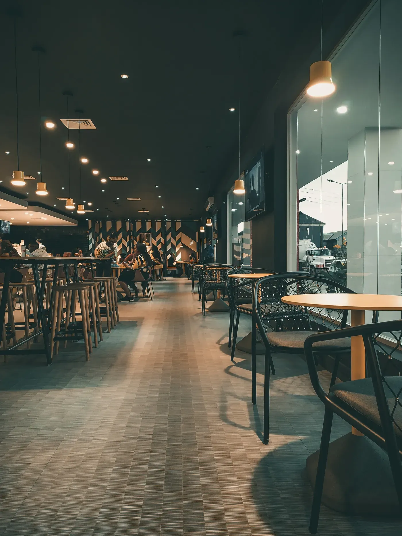 Empty restaurant dining room with high-top tables and pendant lights