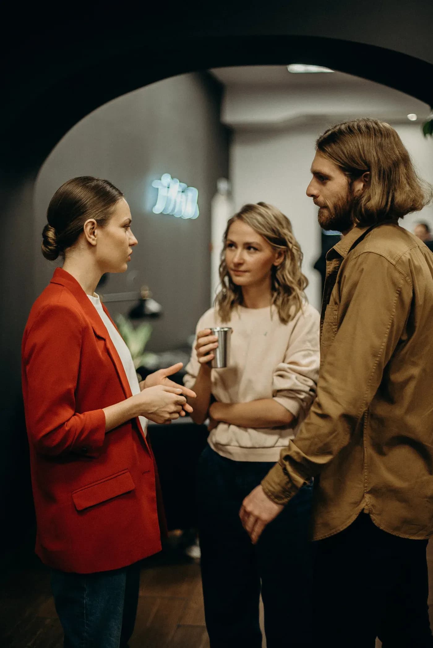 Three people in conversation inside a restaurant